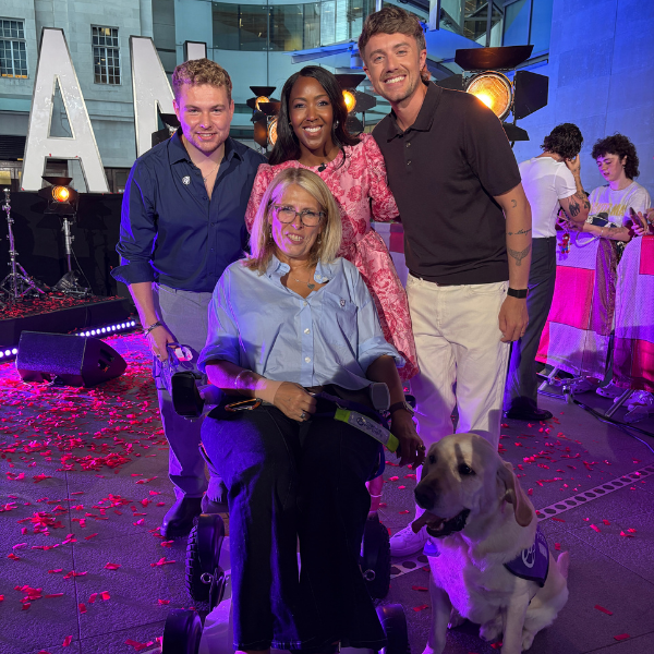 Group photo of lady in wheelchair with dog, her son and one show presenters