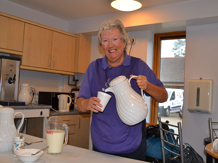 Information session helper volunteer Barbara pouring a cup of coffee