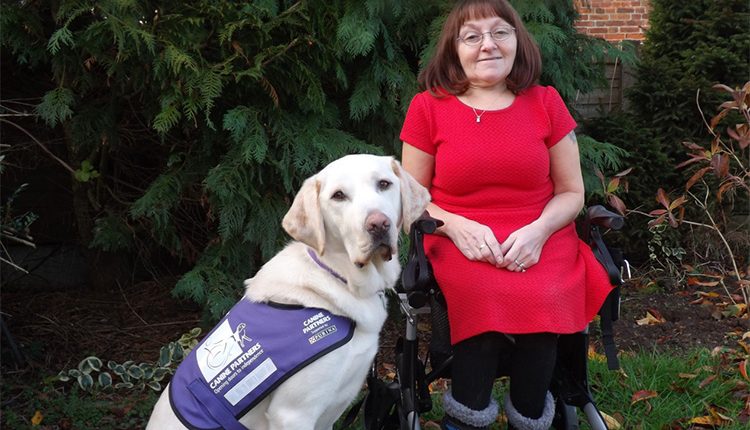 Karen and her assistance dog Gooch sat posing beside her wheelchair