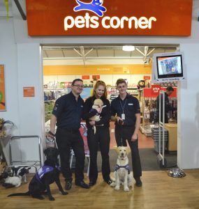 Pets Corner staff at Brighton Racecourse posing with assistance dog puppies in training