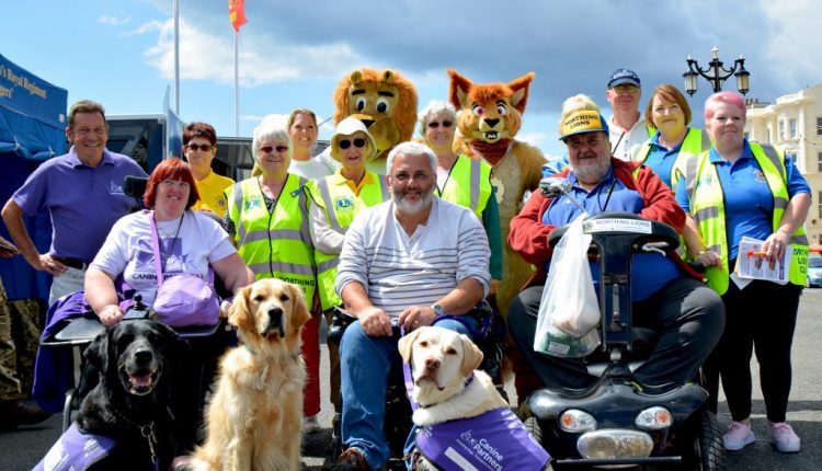 Worthing Lions club with Canine Partners dogs posing on Worthing seafront at Lions Festival