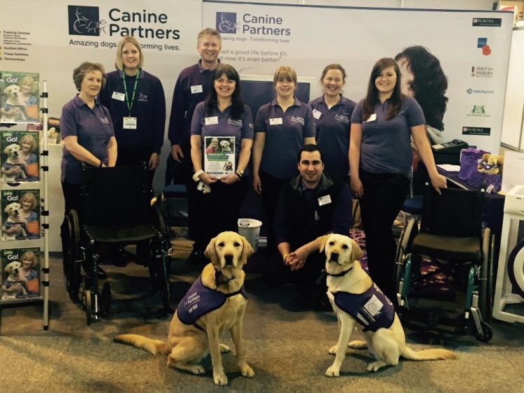 Canine Partners staff and assistance dogs in front of display