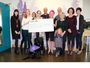 Giant cheque held by group of HSBC staff and family, presented to Canine Partners by HSBC in memory of a colleague.