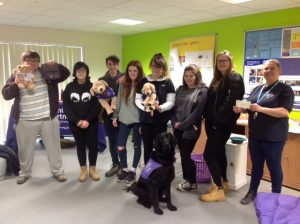 Students at Brinsbury College with Canine Partners merchandise and assistance dog