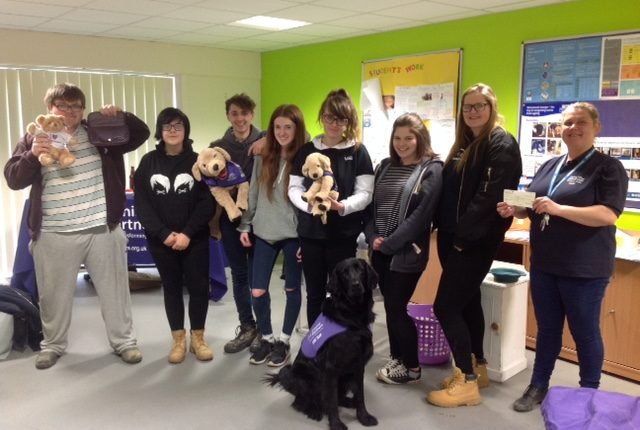 Students at Brinsbury College with Canine Partners merchandise and assistance dog