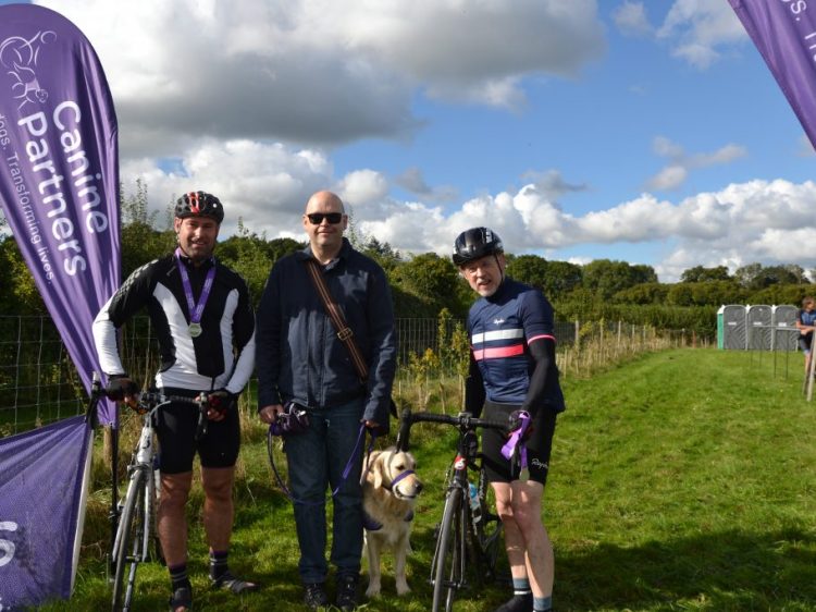 Cyclists with partnership Alan and assistance dog Hamlin at Canine Partners cycling event Pedal for Paws